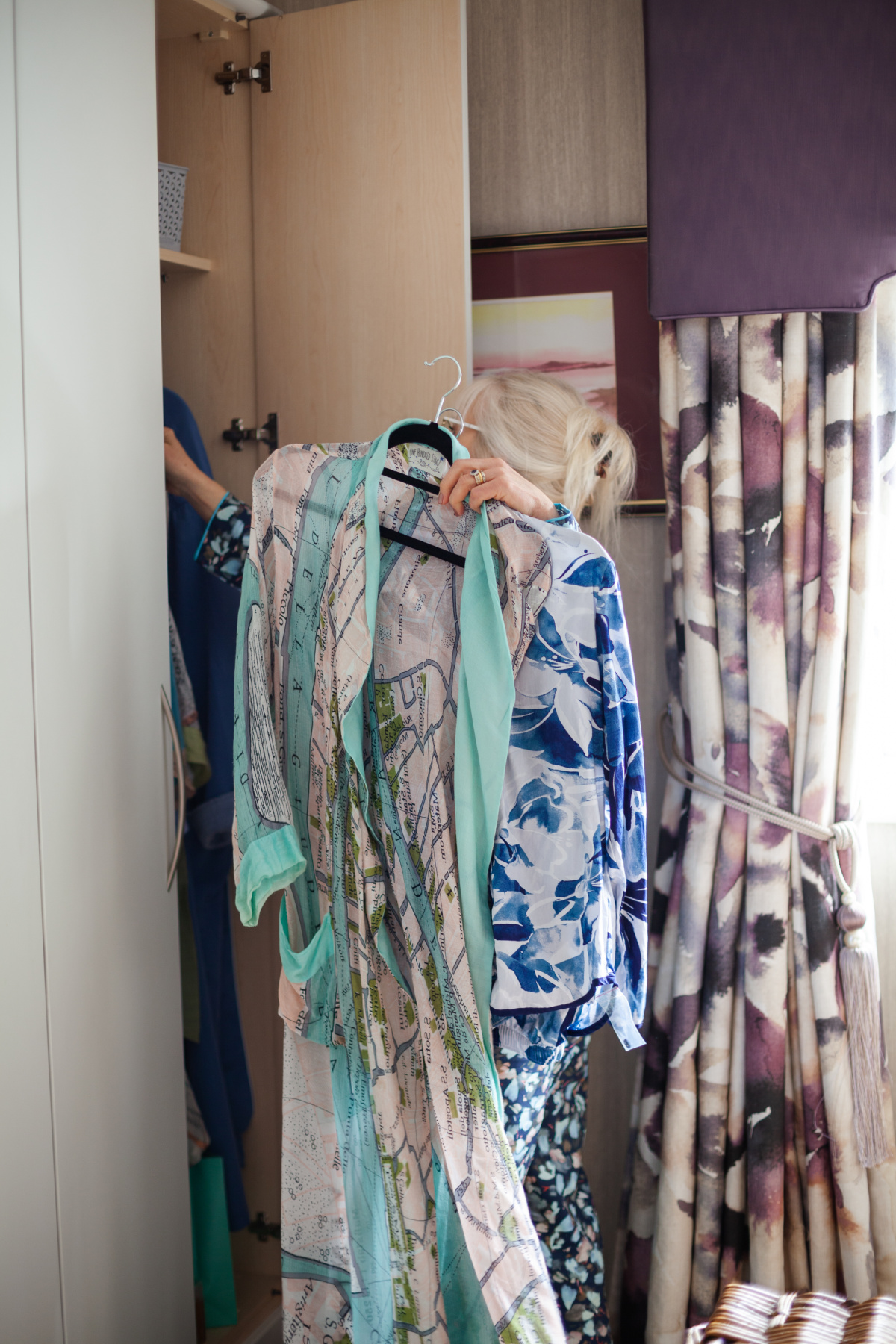 Dressing gowns being removed from a lingerie wardrobe.