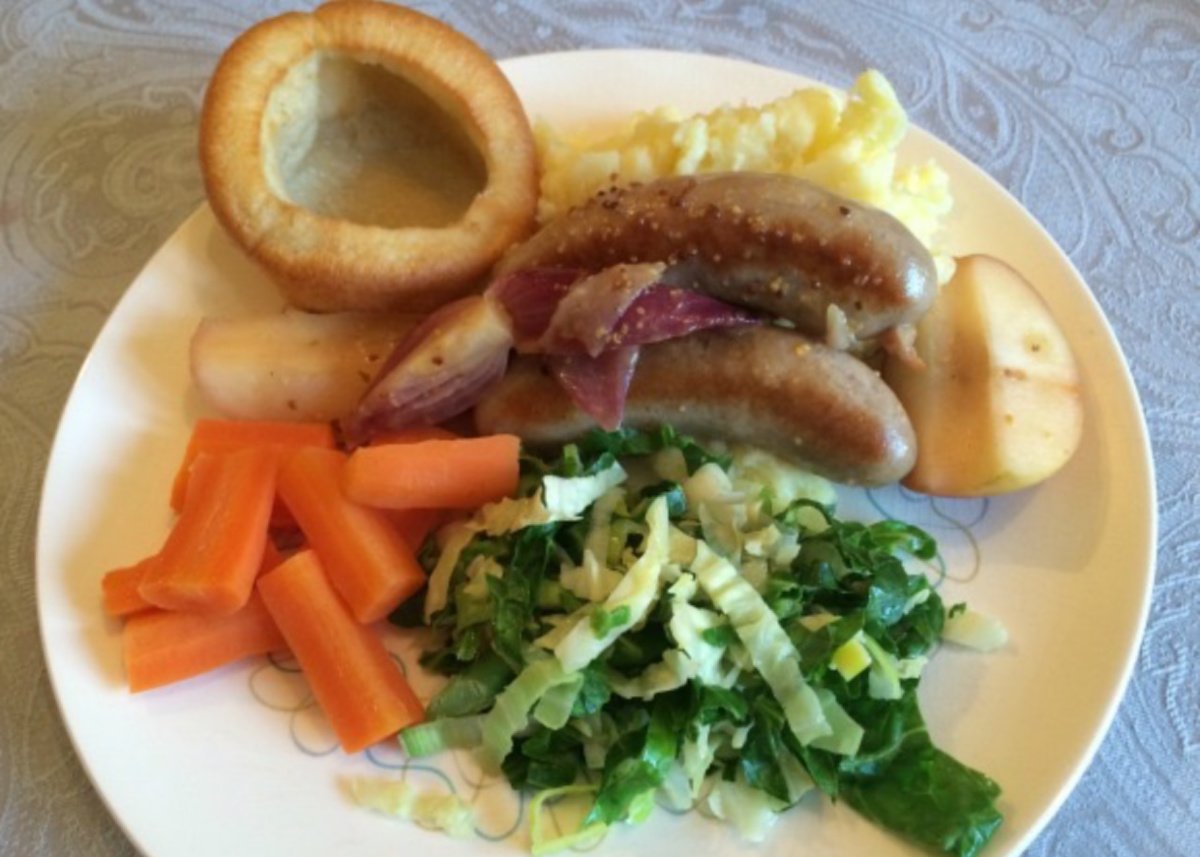 Sausage and Apple One Pot recipe served with a Yorkshire pudding, mashed potatoes, greens and carrots