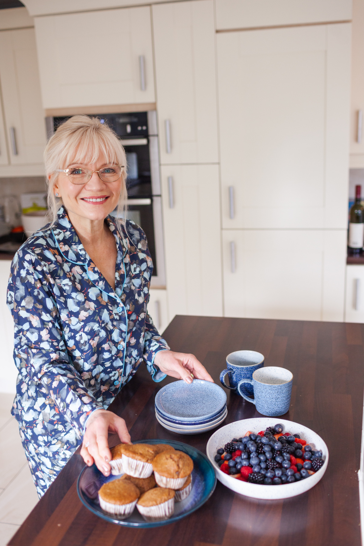April Harris taking a muffin from a plate of muffins