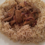 Lighter Beef Stroganoff served over brown rice on a white plate