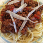 A serving of Vegetarian Spaghetti Bolognese served with vegetarian cheese on top