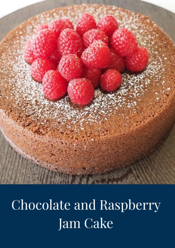 Chocolate and Raspberry Jam Cake dusted with icing sugar and topped with raspberries