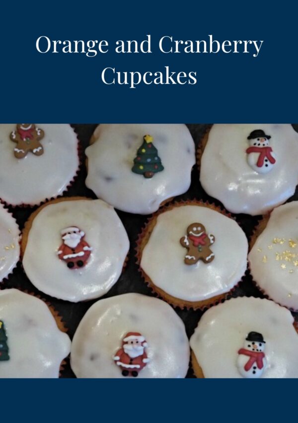 Orange and Cranberry Cupcakes decorated with vanilla icing and Christmas toppings