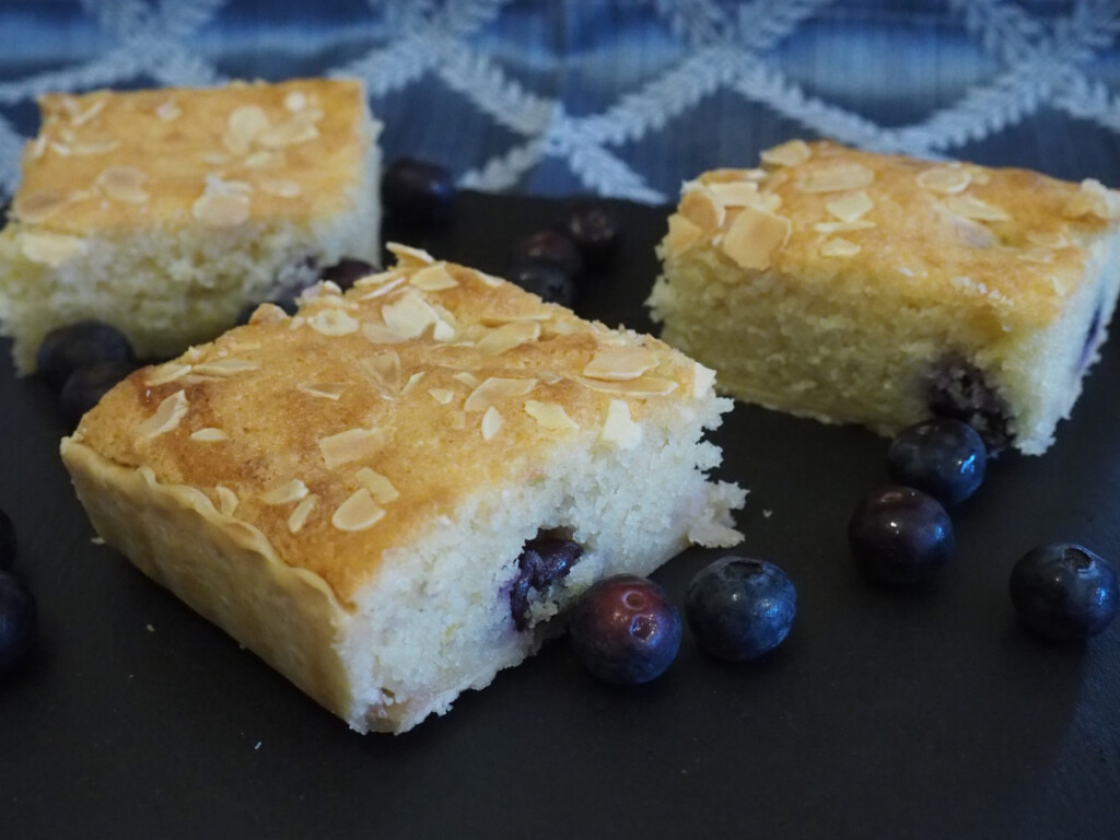 Blueberry Bakewell Tart Squares served on a slate with Blueberries alongside