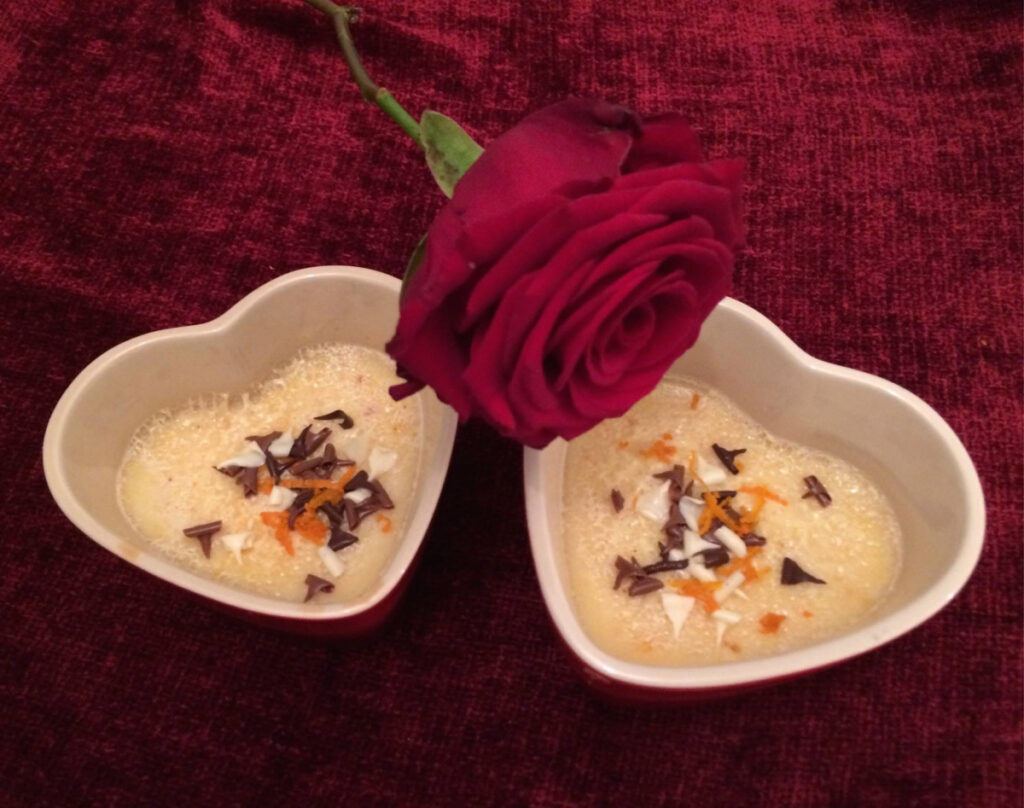 Two St Clement's Custards made in heart shaped ramekins with a red rose