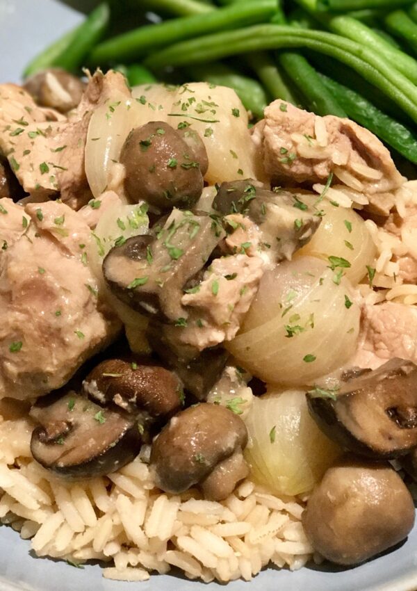 Blanquette de Veau served over rice with steamed green beans on the side