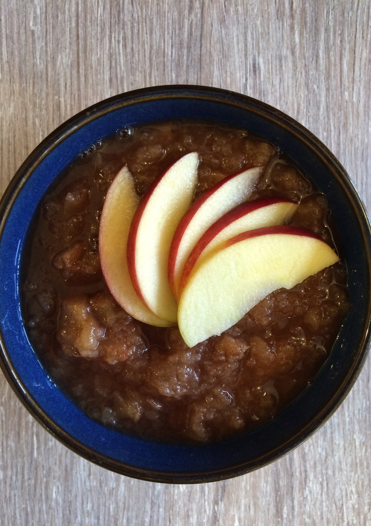 Crock Pot Apple and Pear Sauce served in a bowl with sliced apples fanned on top for decoration