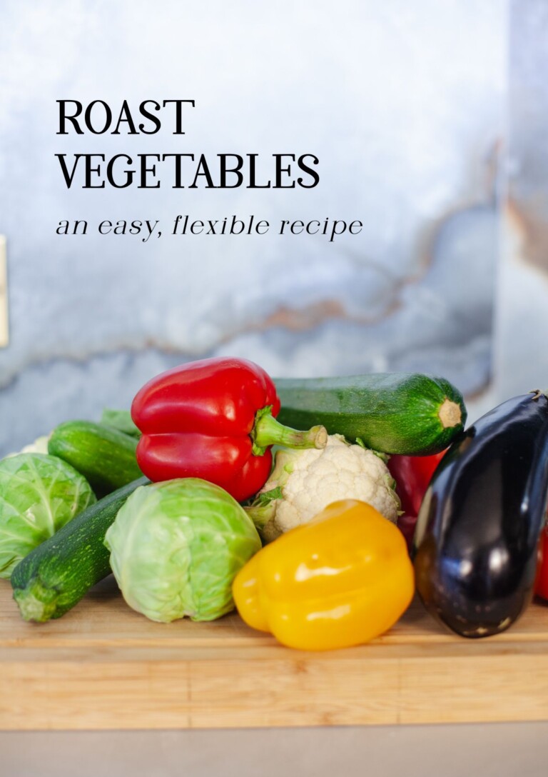 Header shot for Roast Vegetables recipe - raw whole vegetables on a chopping board, red and green pepper, aubergine, cabbage, courgette etc