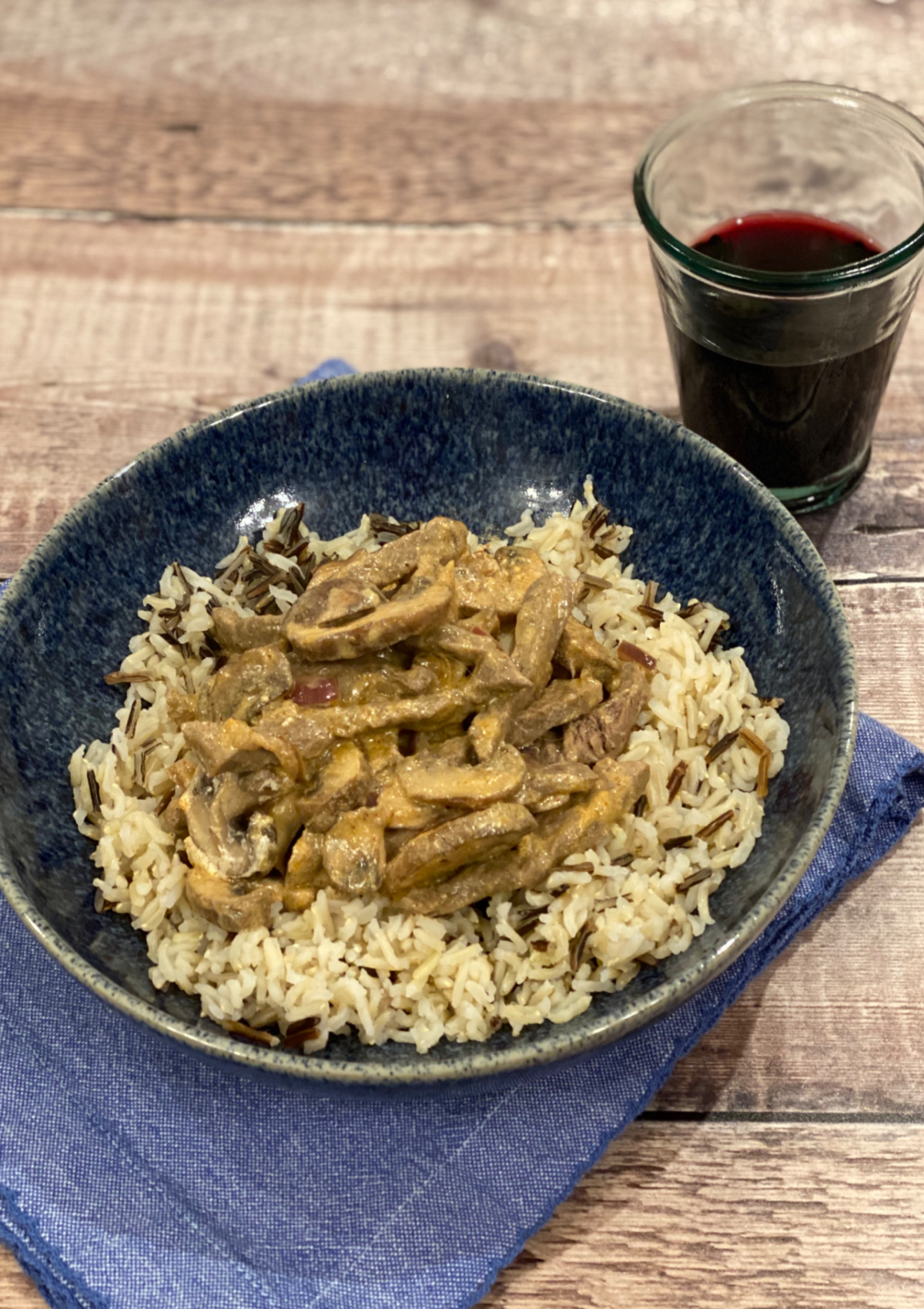 Beef Stroganoff served over rice in a blue bowl