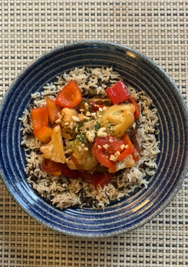 Kung Pao Cauliflower served over rice in a blue bowl