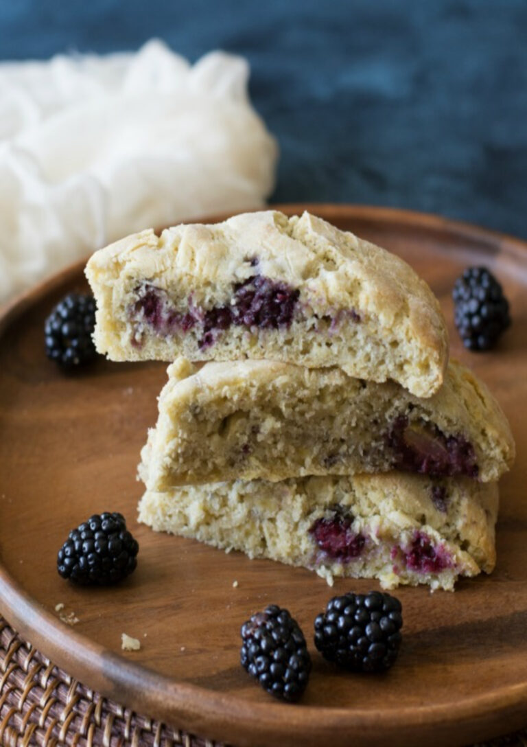 Three Gluten-Free Blackberry and Apple scones stacked and served on a wooden plate