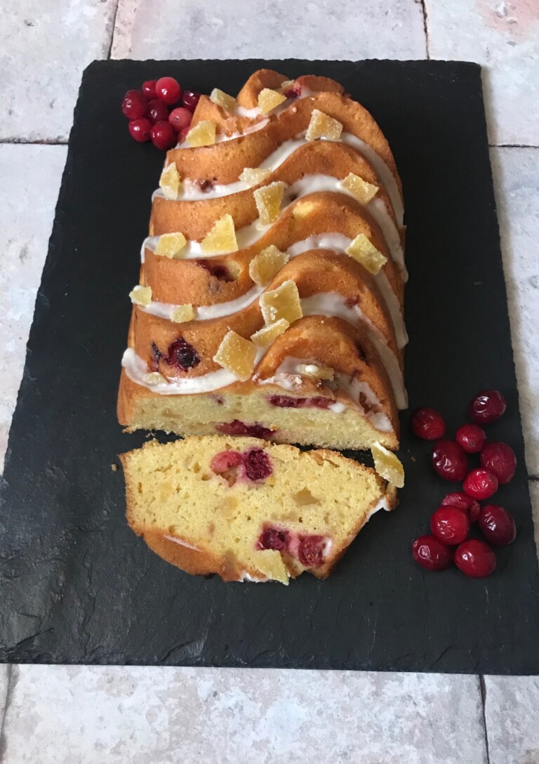Cranberry Orange and Ginger Loaf Cake served on a slate.