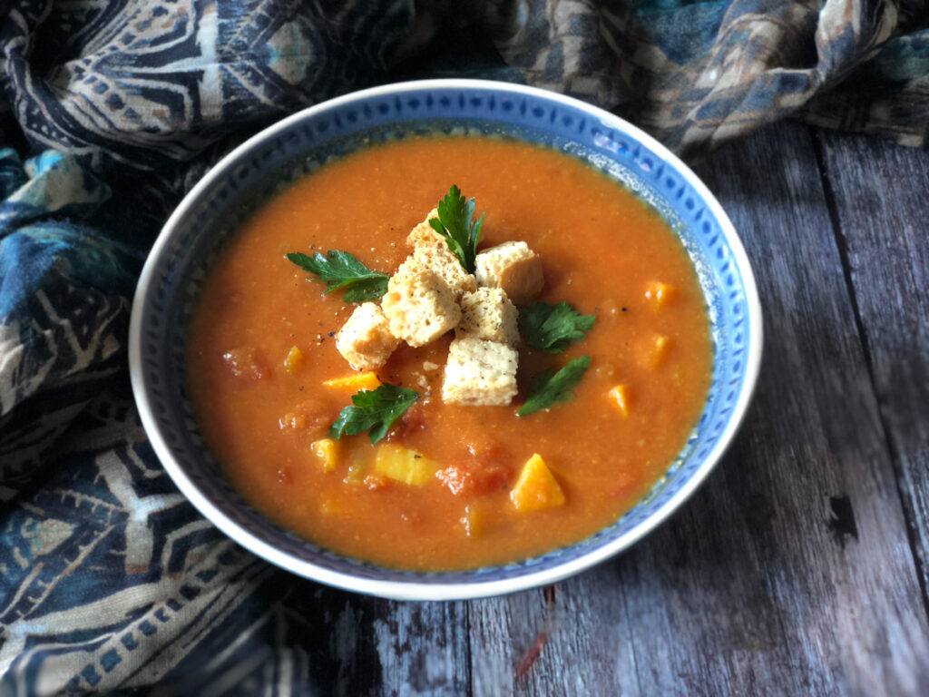 Vegetarian Mulligatawny Soup served in a blue bowl, topped with croutons and parsley