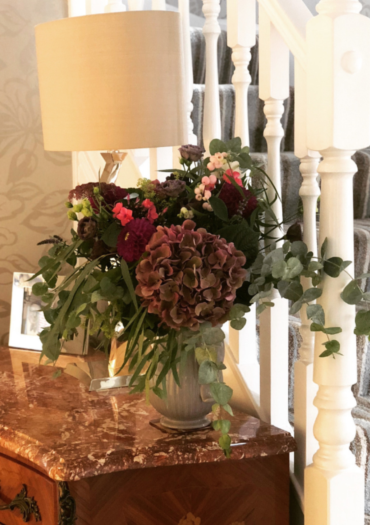 Freshen up your home for fall - a console table with a lamp and fall floral arrangement 