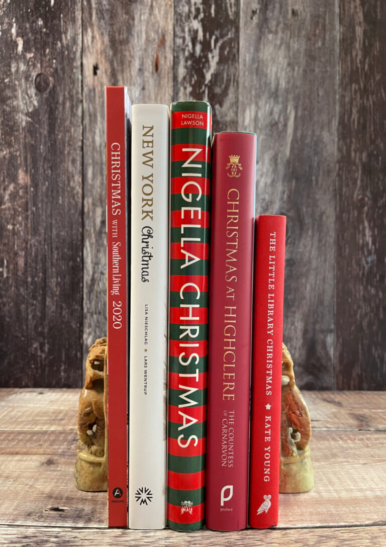Five Christmas Cookbooks with red, green and white spines held together by two bookends