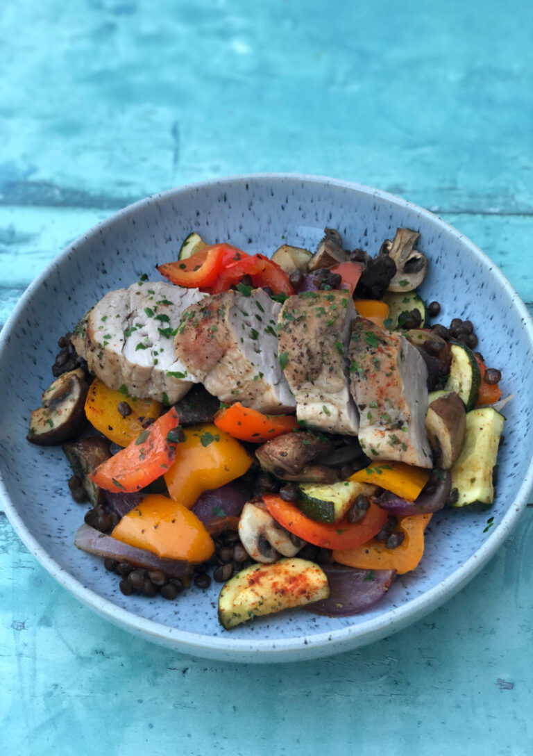 Pork Tenderloin with Lentils and Mediterranean Vegetables served in a blue bowl