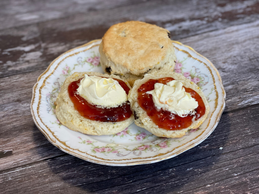 Grandma's Orange and Raisin Scones, one spilt and served with jam and cream, on a Limoges plate