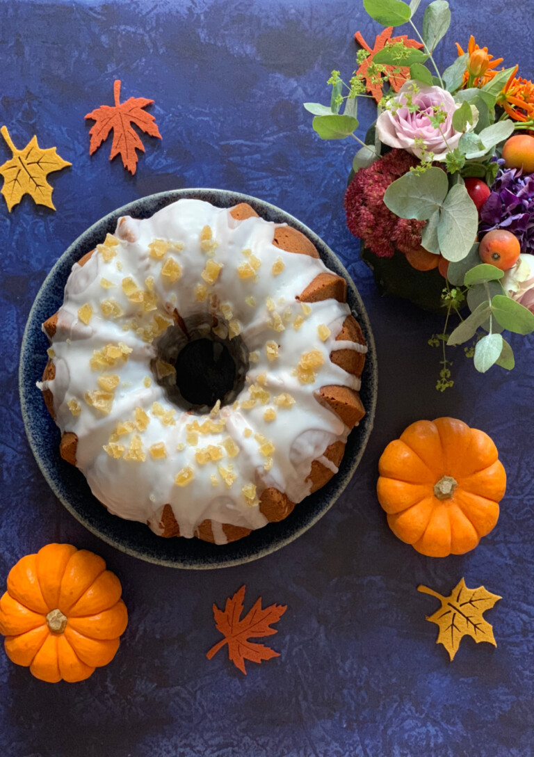 a Pumpkin Bundt Cake with glaze and crystallised ginger pieces photographed from a above