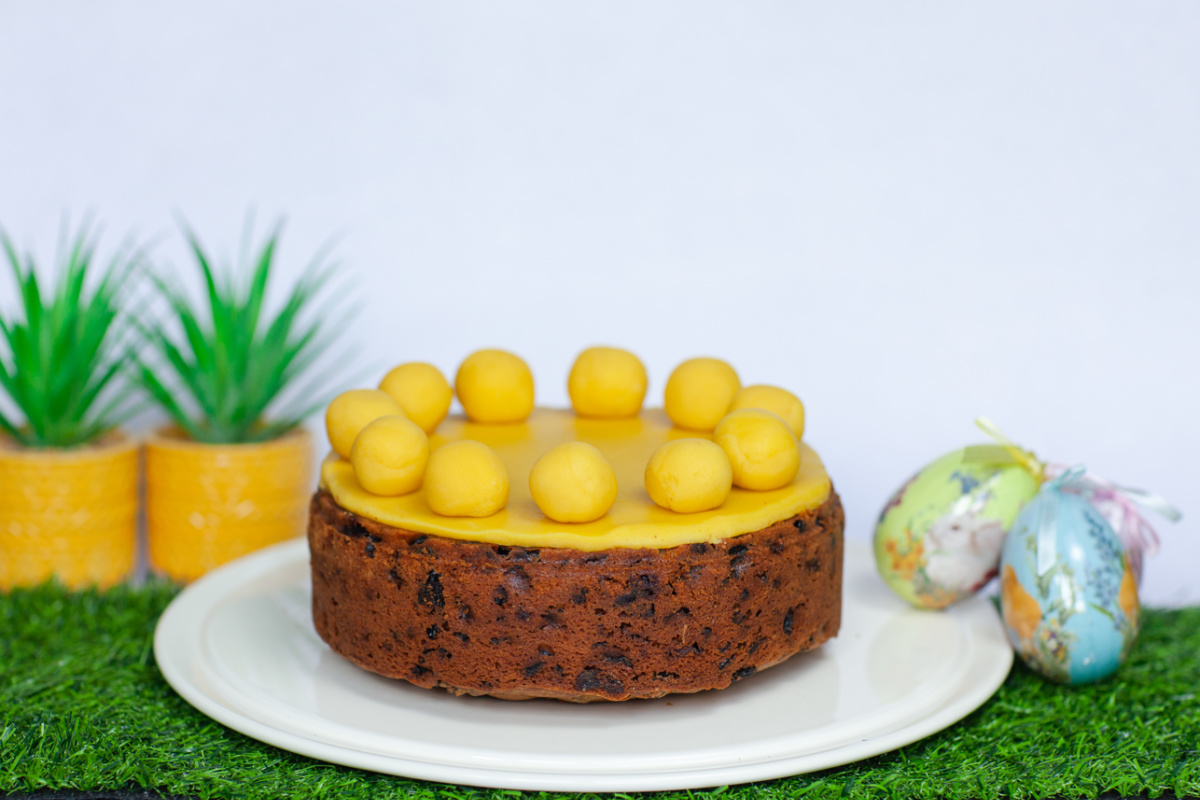A Simnel Cake sitting on a white cake plate