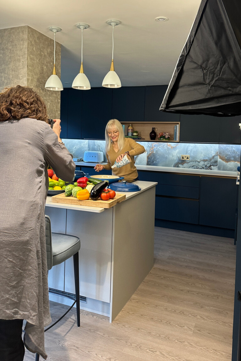 Key photograph for how to feel comfortable in front of a camera - April Harris in her kitchen being photographed by Terry Joshi