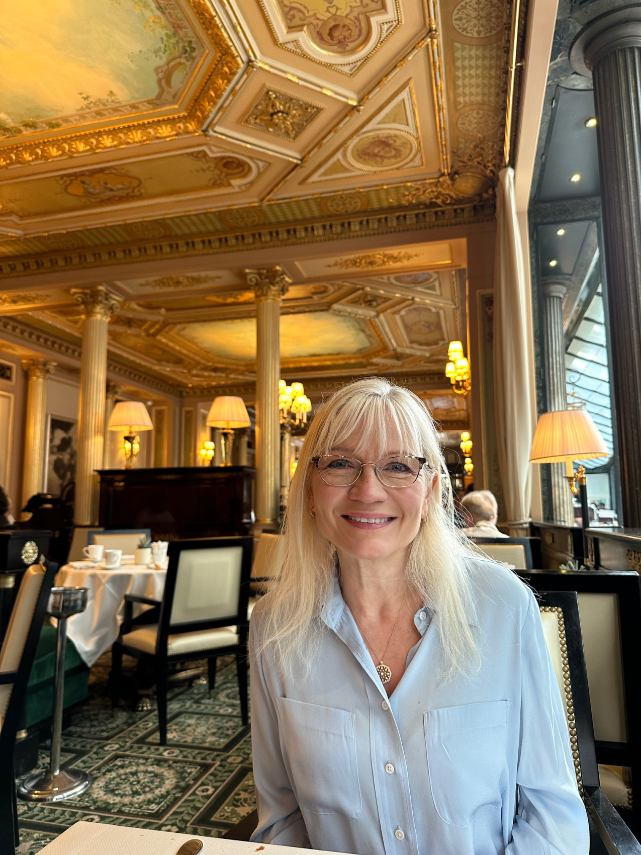 April Harris sitting in one of her favourite Paris restaurants The Café de la Paix