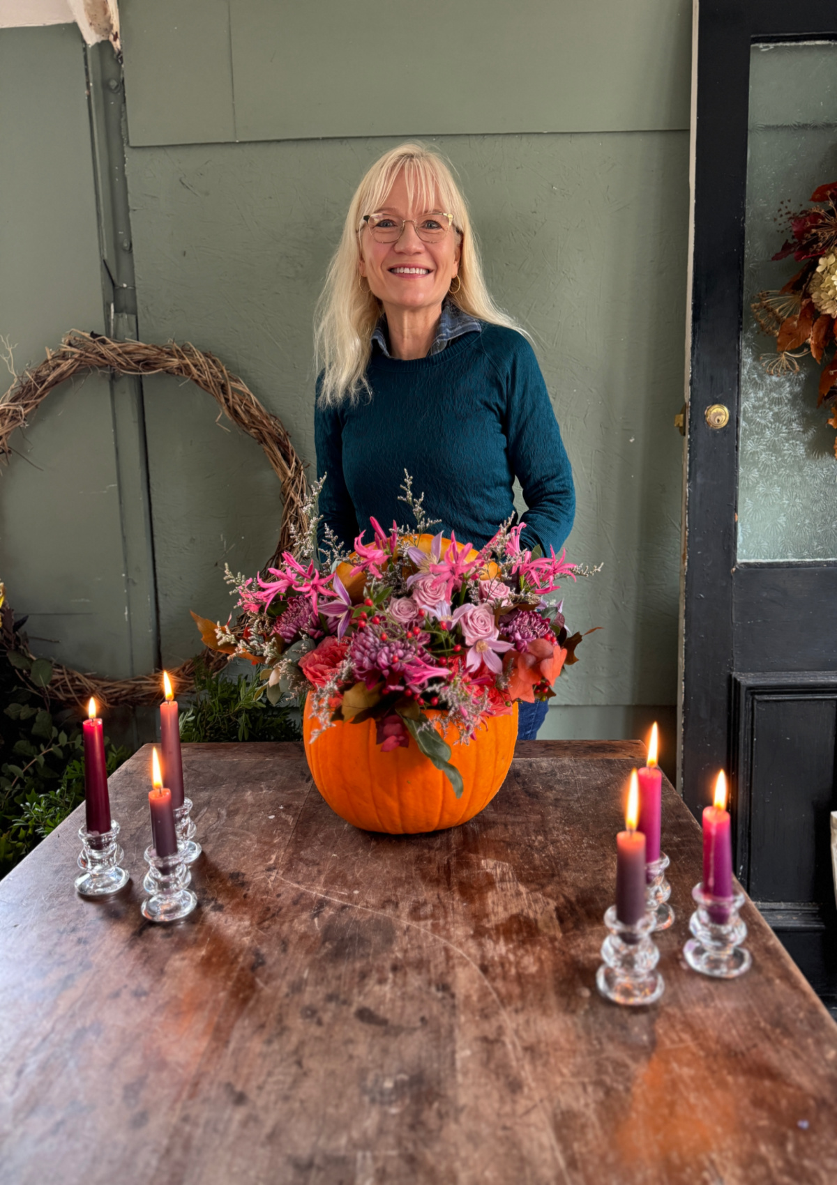 Great things to do in October header shot - April J Harris with a pumpkin floral centrepiece she made
