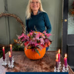 Ideas and Inspiration for Great Things to Do In October Pinterest pin April J Harris pictured with a flower-filled pumpkin centrepiece she has just made