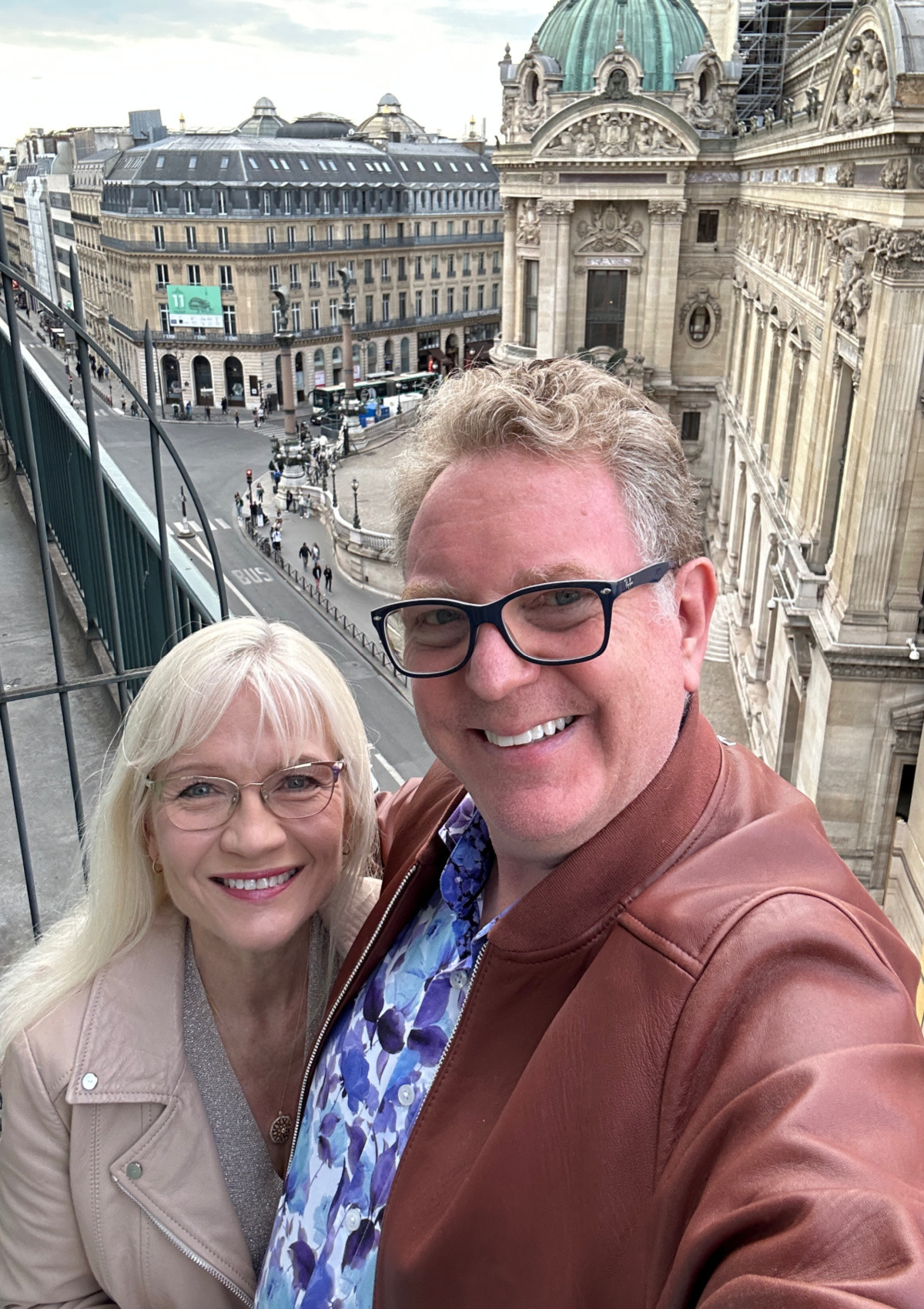 April and Guy standing on the balcony of the Hotel Royal in Paris overlooking the Opera.