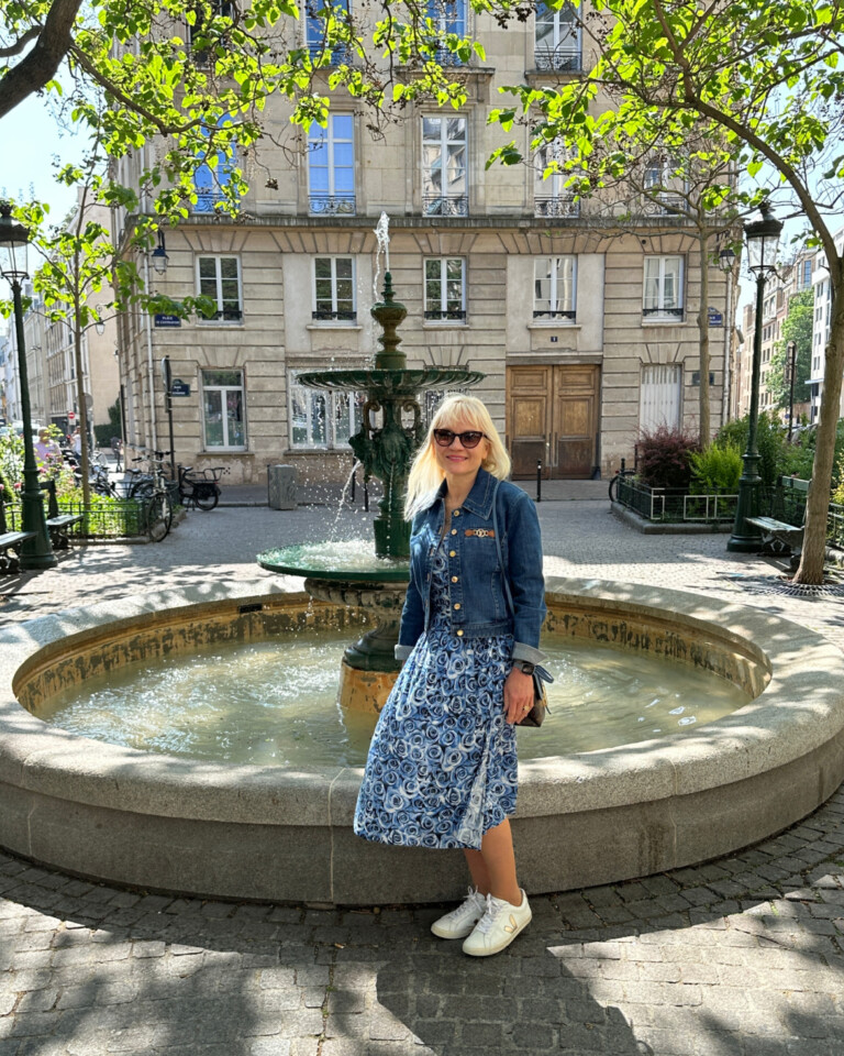 April Harris standing in front of a fountain used in the filming of Emily in Paris