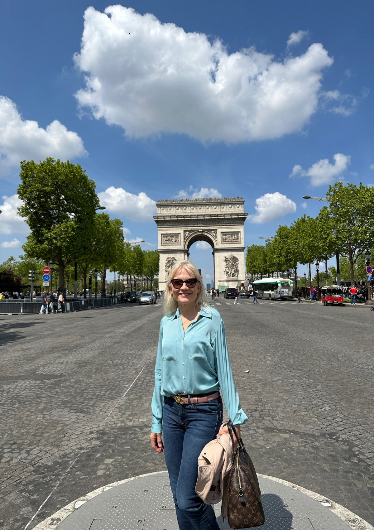 April Harris visiting Paris pictured on the Champs Elysees with the Arc de Triomphe in the background