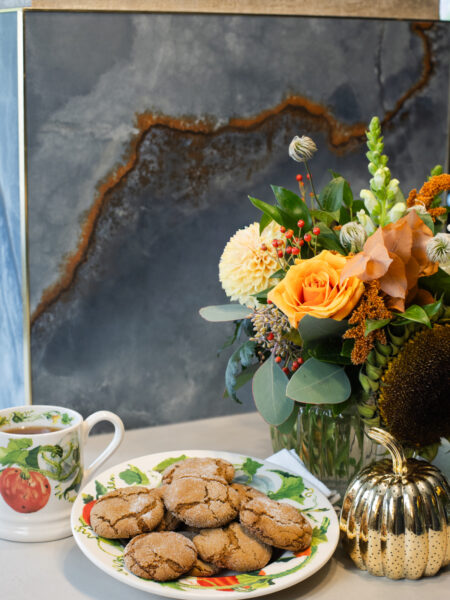 Orange Gingerbread Cookies served on an Emma Bridgewater plate with a vase of autumn flowers and a matching mug in the background
