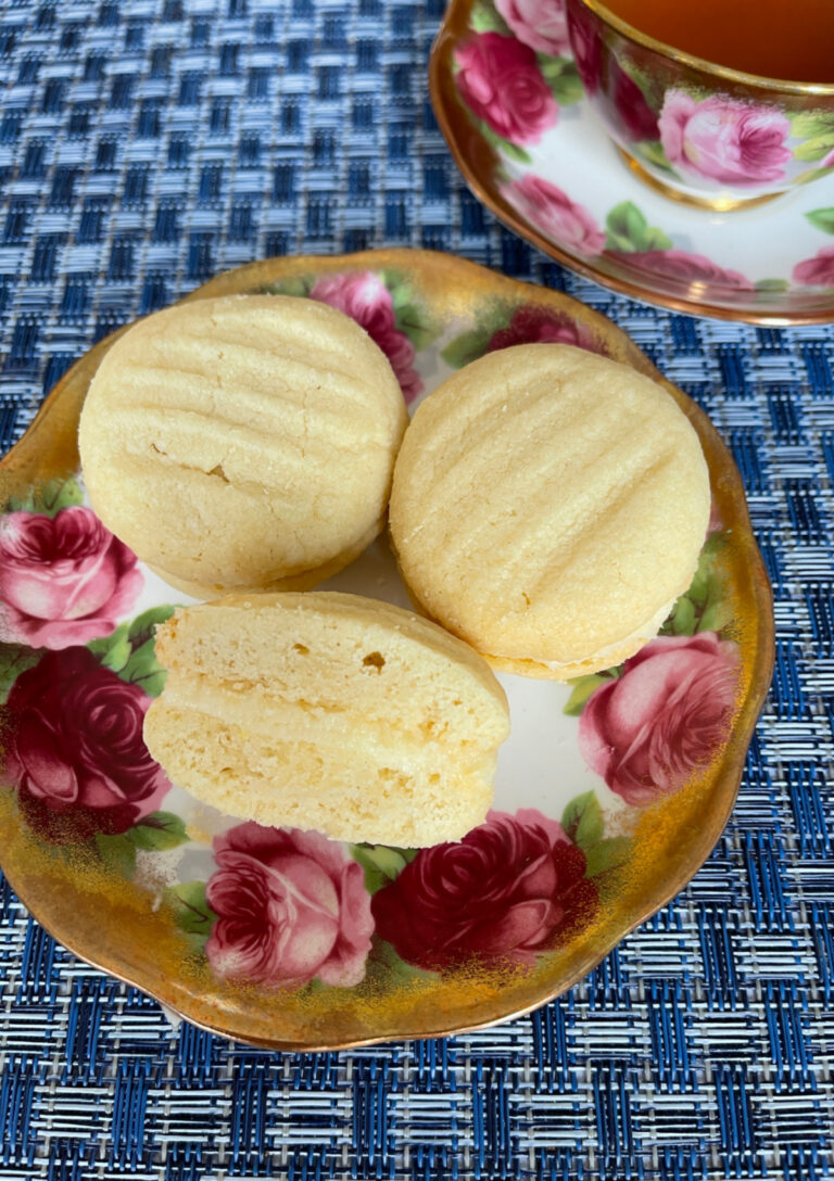 Melting Moments cookies with a rich buttercream filling served on a china plate with a rose design.