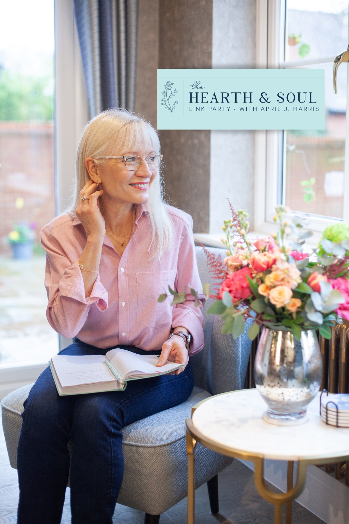April Harris sitting in on a blue chair with a book on her lap - Hearth and Soul header image August