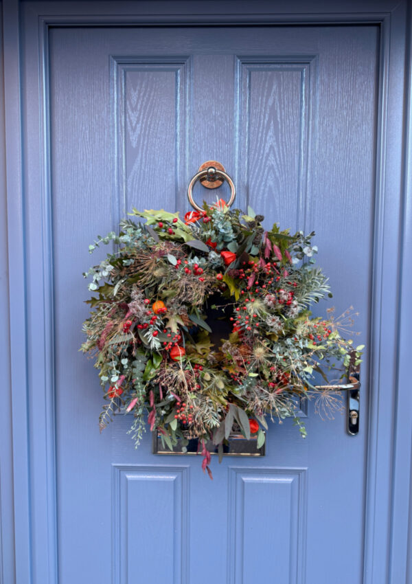 Fall decorating ideas for front doors - a beautiful autumn wreath made of natural materials on a blue front door