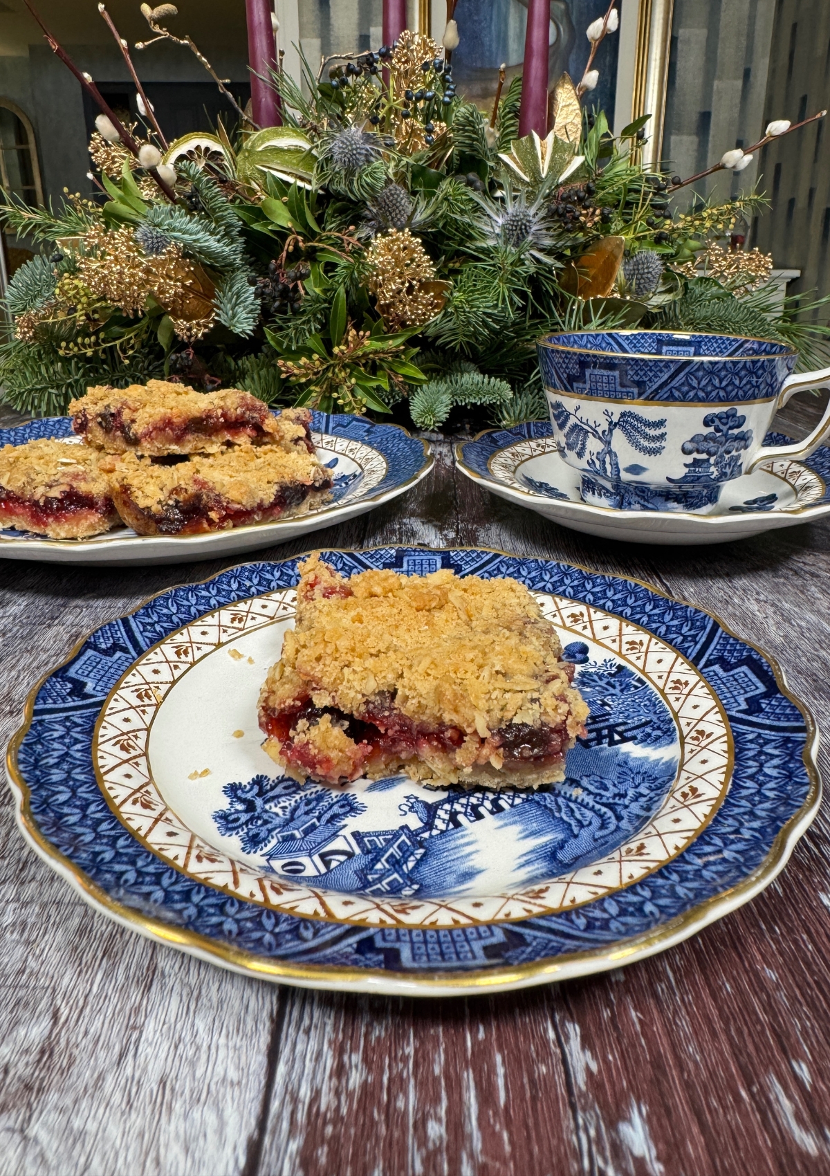 Cranberry Oat Crumble Bars cut and served in a Christmas setting on Blue Willow Plates